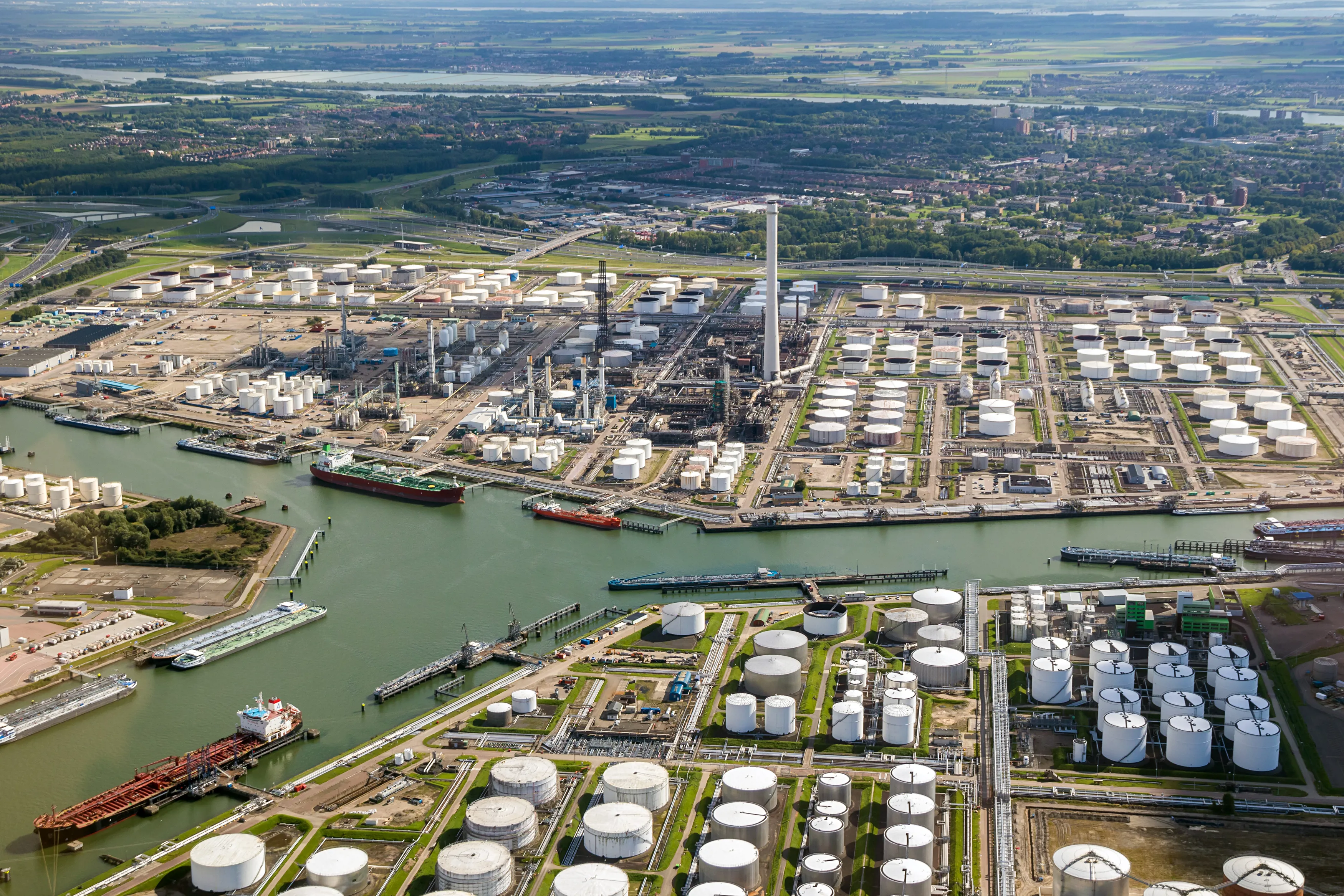 Aerial view of oil tankers moored at a oil storage terminal and oil refinery in a port.