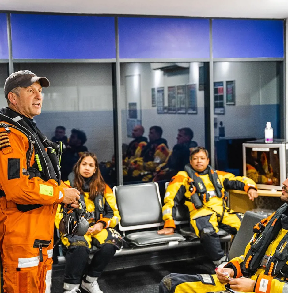 Staff in life jackets and uniform having a discussion