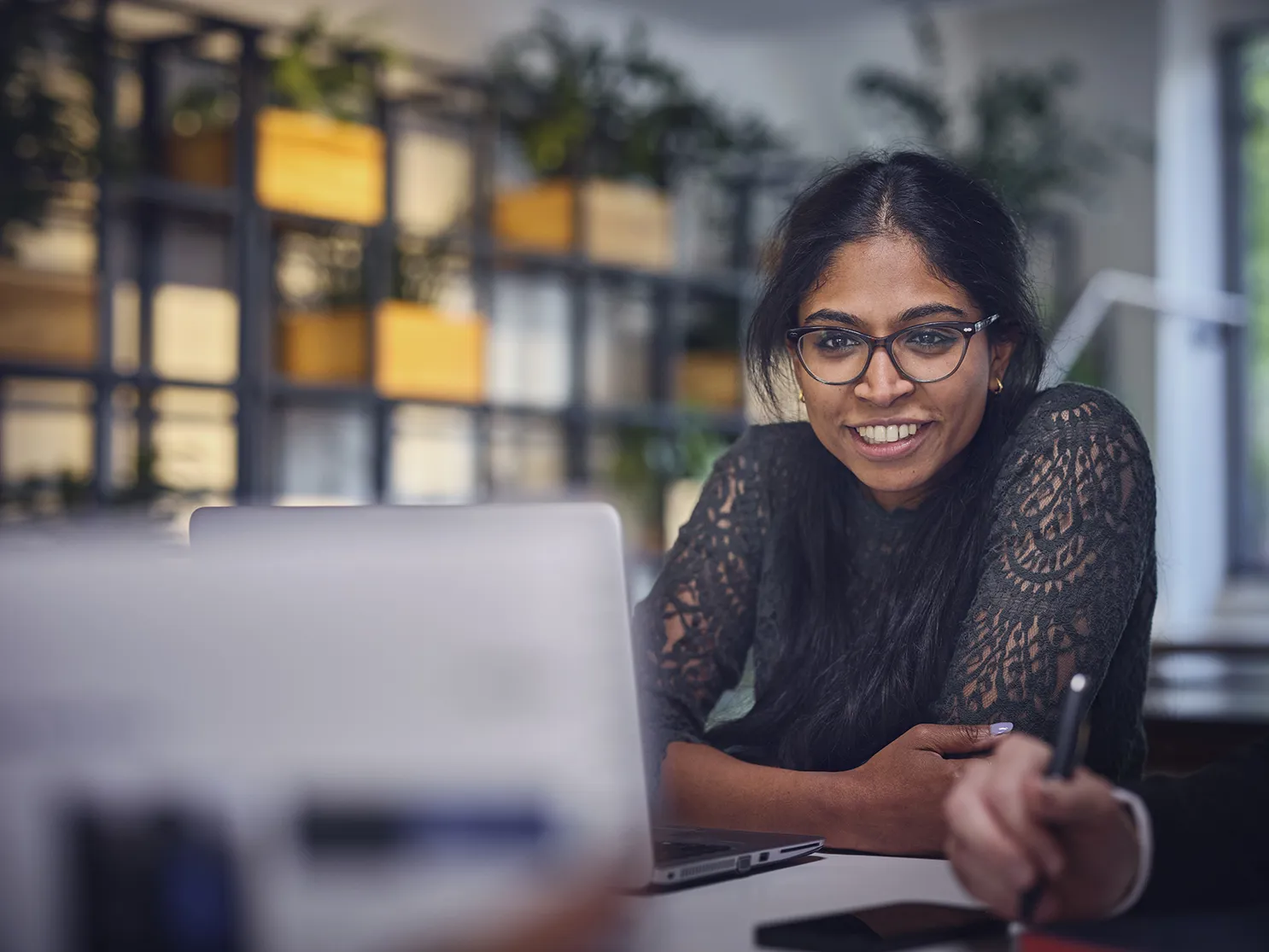 woman sitting at table with her laptop and smiling