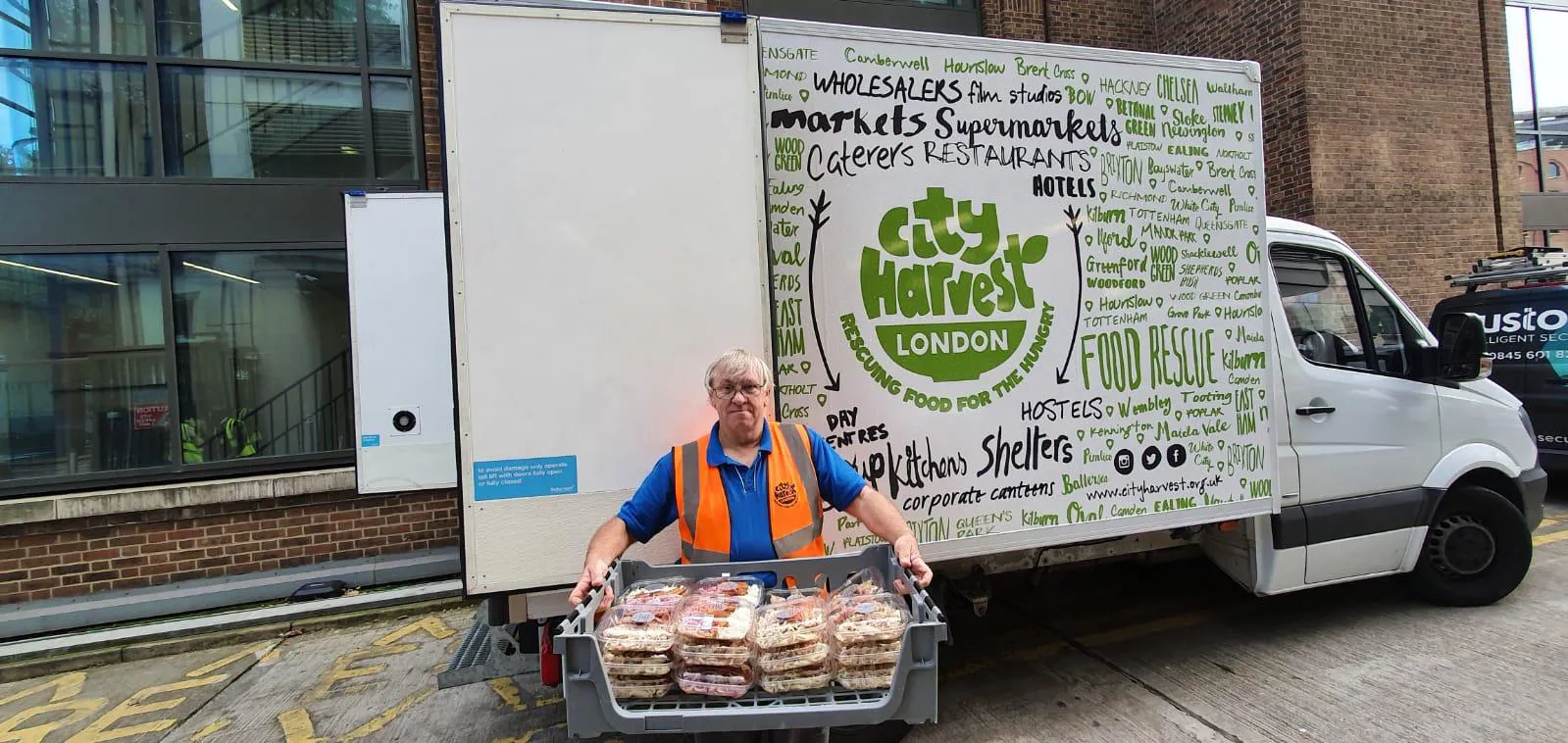 man carrying tray of food into van